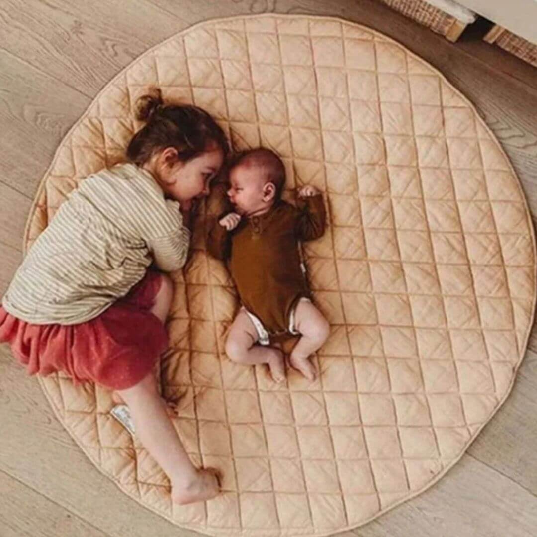 Tapis-d'éveil-bébé-rond-carreaux-position-sur-le-dos