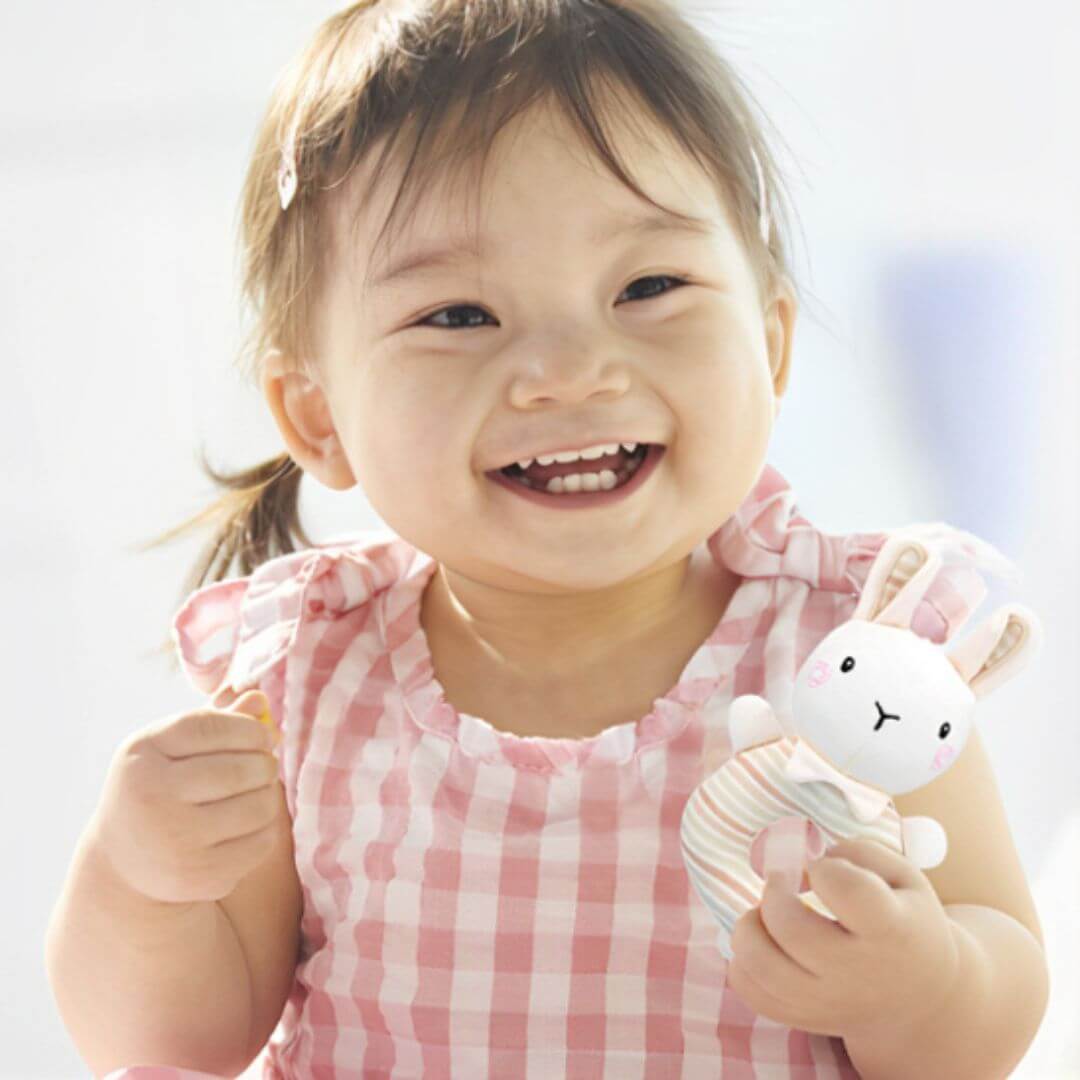 Fille heureuse avec le Hochet bébé 3 mois
